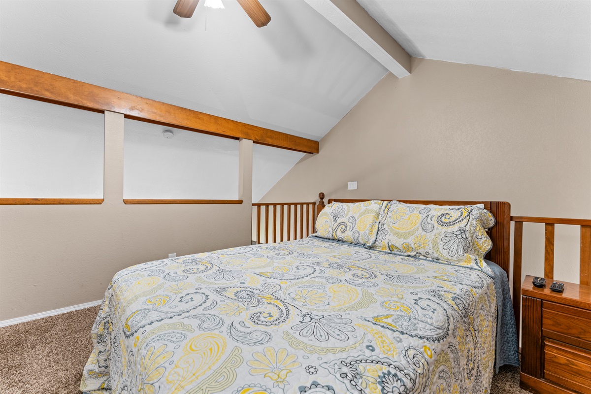 The loft bedroom feels cozy and private while staying connected to the home’s open layout.