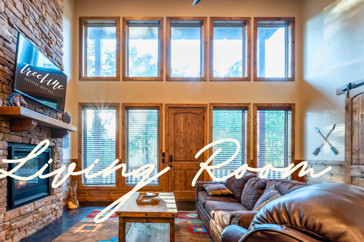 Relax in the cozy living room, offering ample seating and a beautiful view of the surrounding woods.