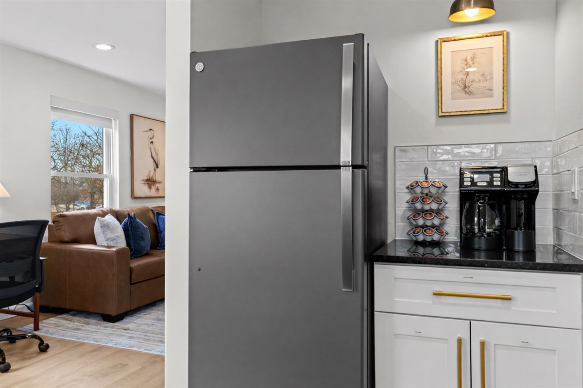 Convenient kitchen nook with full-size fridge, coffee station, and extra storage—perfect for morning routines and keeping everything organized.
