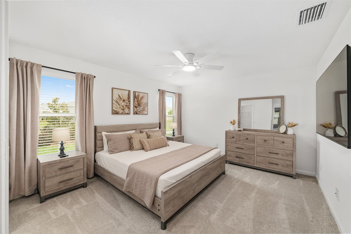 Retreat to a spacious and serene master suite designed for comfort and relaxation.
Featuring a plush king bed, calming neutral tones, and a large TV, this cozy space is perfect for unwinding after a day exploring The Villages.