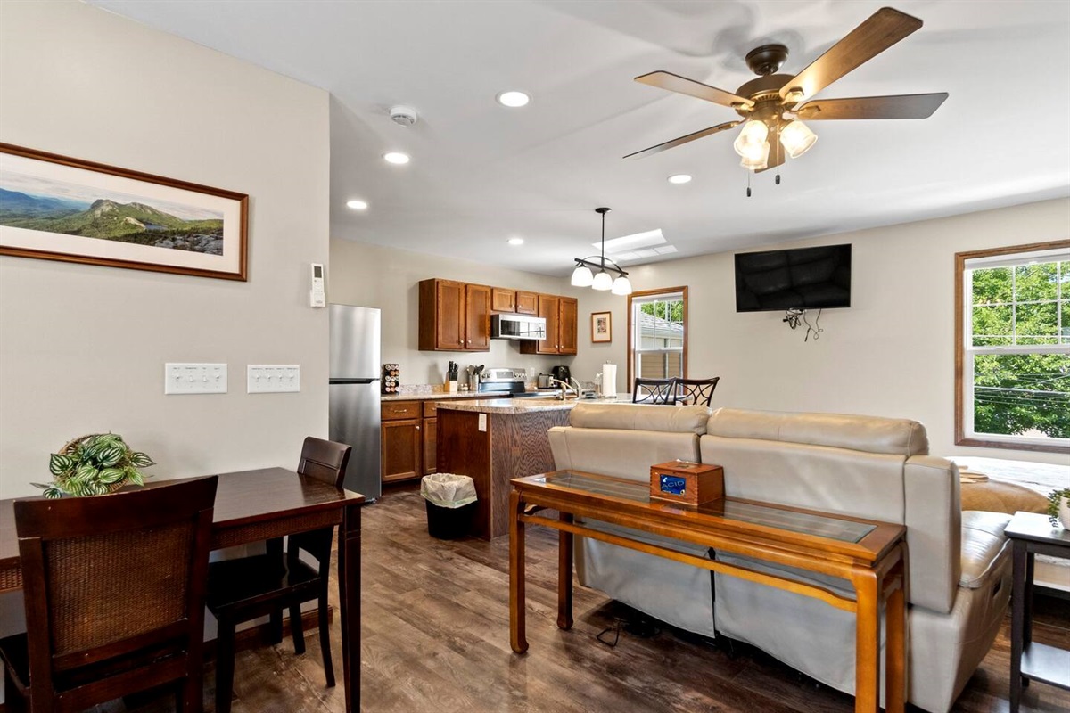Spacious living area with a TV, comfortable couches, and direct access to the dining area, creating a seamless flow for relaxation and meals.