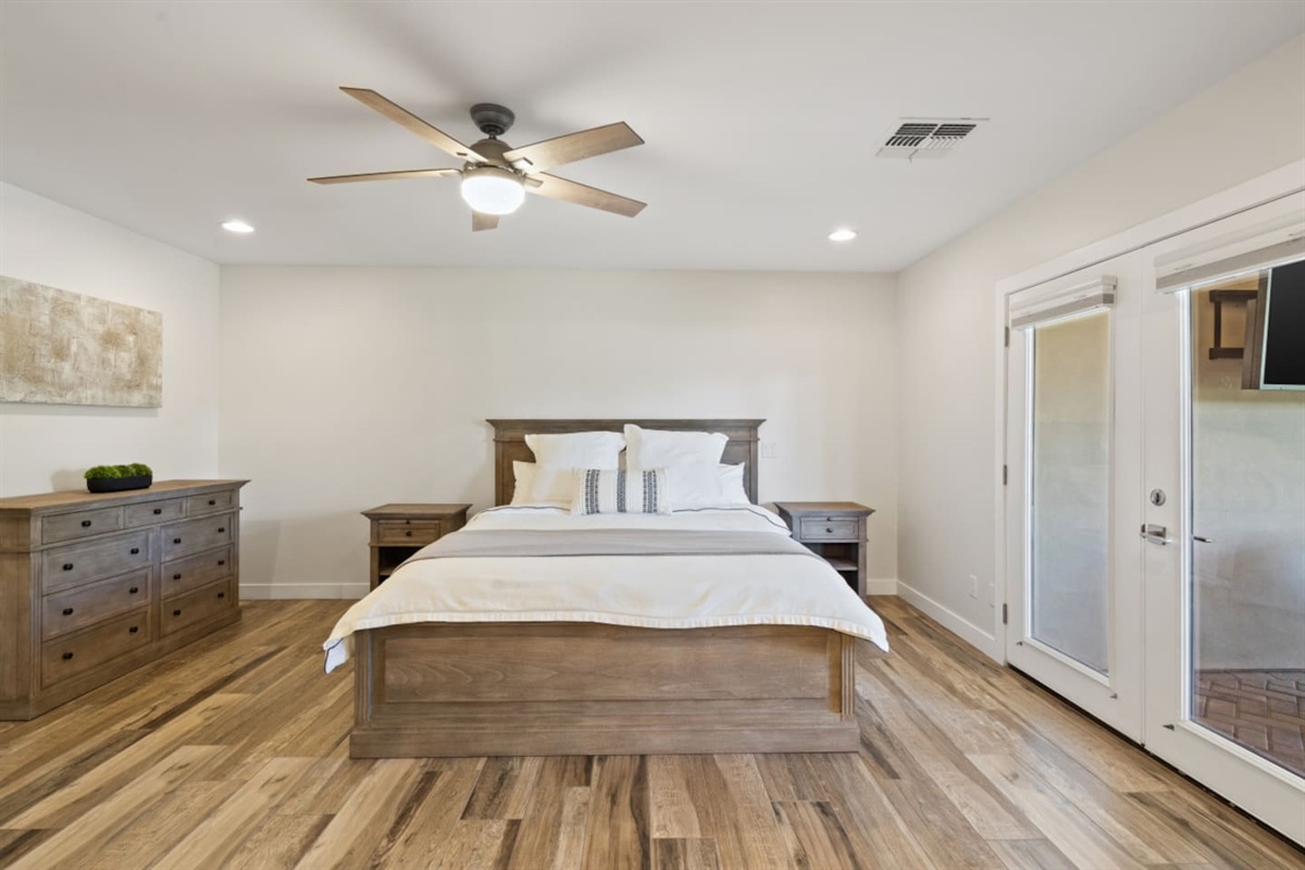 Main ensuite bedroom with queen bed, clean bedding, storage, and a simple restful layout.