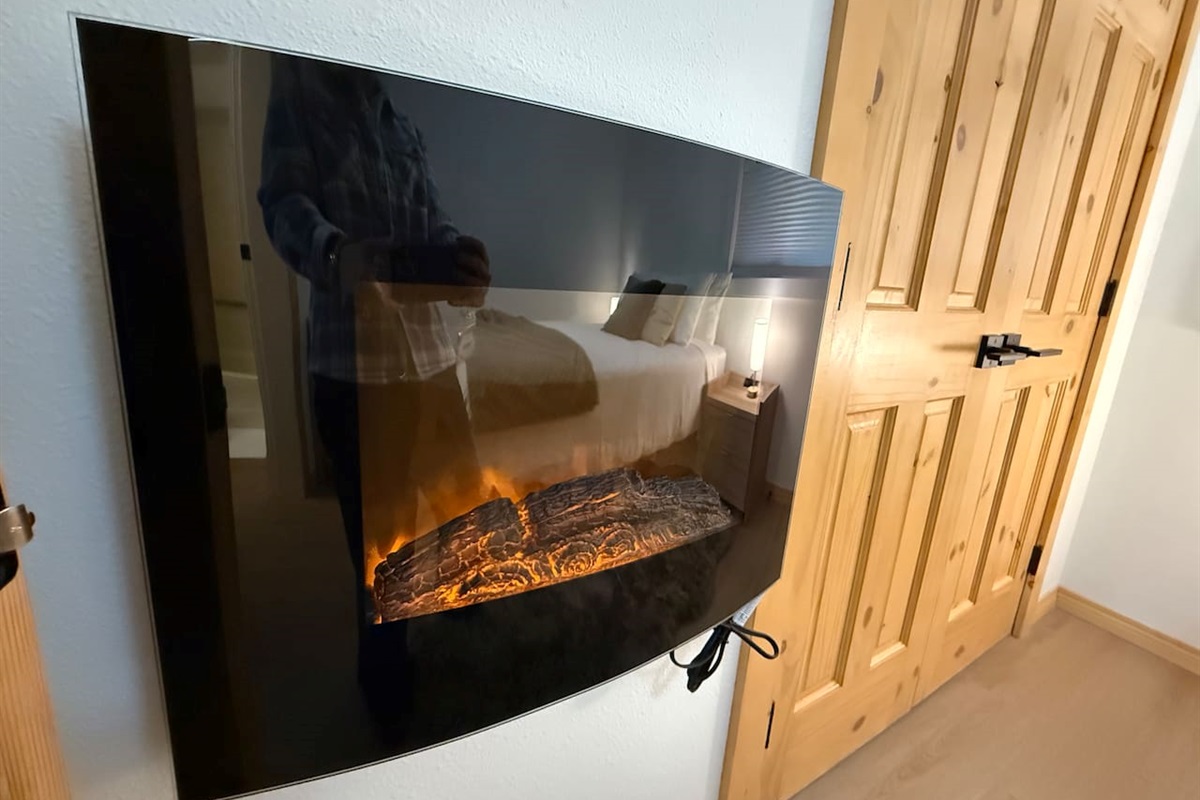 Cozy Ambiance: Warm up after a day on the slopes with the built-in electric fireplace feature in this cozy Kimberley main floor bedroom.