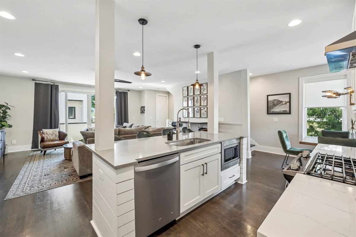 Modern kitchen with quartz countertops, stainless steel appliances, and bold backsplash - Spacious island with seating, ideal for breakfast, wine nights, or work time - Warm pendant lights and curated finishes elevate the entire culinary space