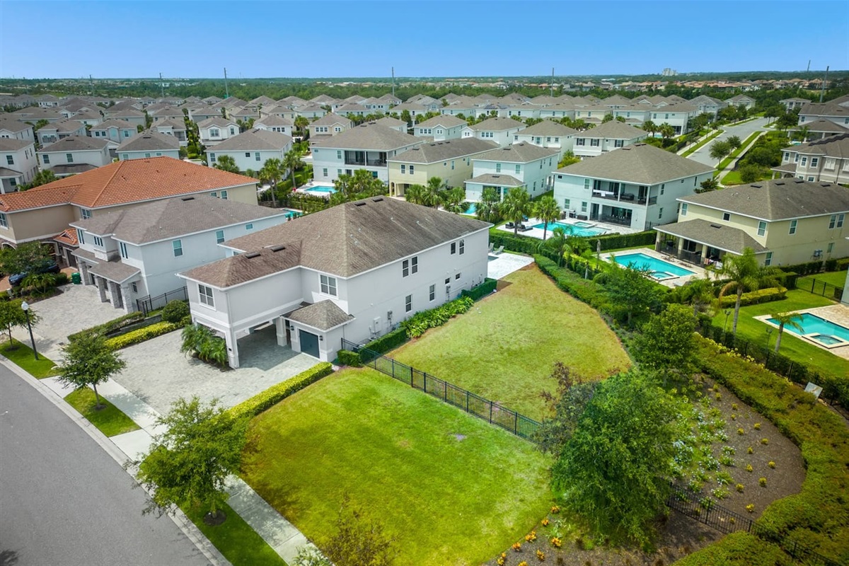 Aerial view of a charming home with lush greenery beside the property, perfect for peaceful walks. The house sits in a serene setting, offering spacious surroundings, natural beauty, and a relaxing atmosphere for a tranquil stay.