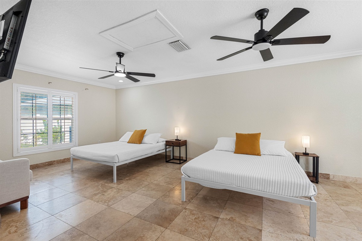 This inviting space features two plush queen-sized beds, each outfitted with soft, hotel-quality linens, cozy comforters, and an abundance of pillows to ensure a restful night’s sleep for every guest.