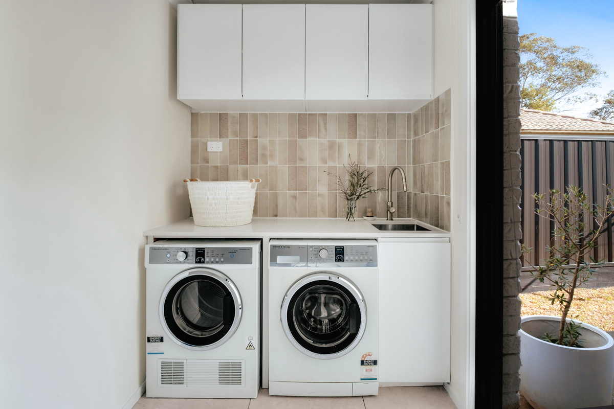 The laundry has a front-load washer, separate dryer and bench space, making everyday washing simple during the stay.