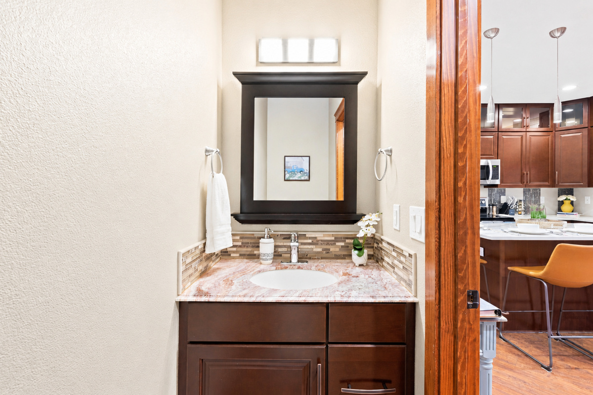 Discover chic simplicity in our powder room, a stylish oasis for quick refreshes and moments of tranquility. This intimate space offers a touch of elegance to enhance your stay.