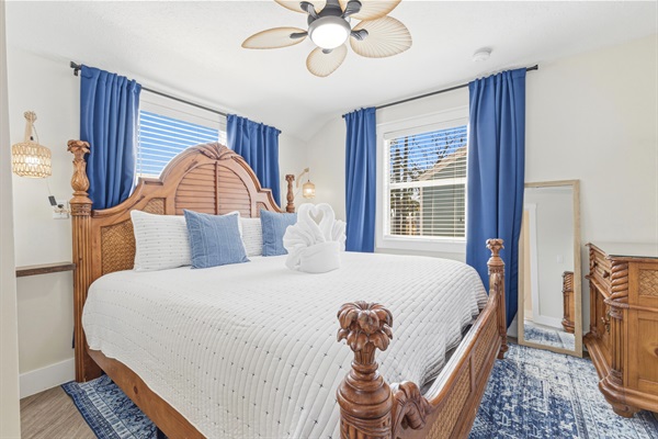 Primary bedroom designed for rest with King sized bed, blackout curtains, Smart TV, full sized mirror.