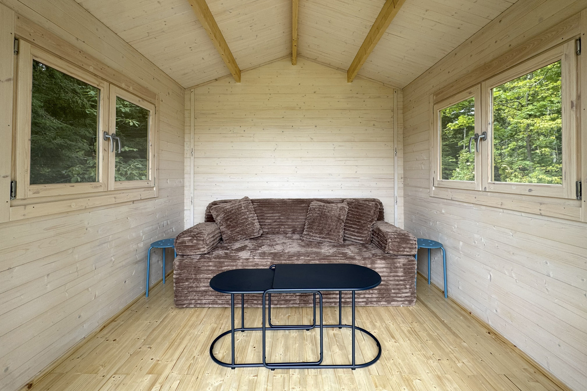 Unwind with a good book in this cozy, light-filled sitting area surrounded by peaceful woodland views.