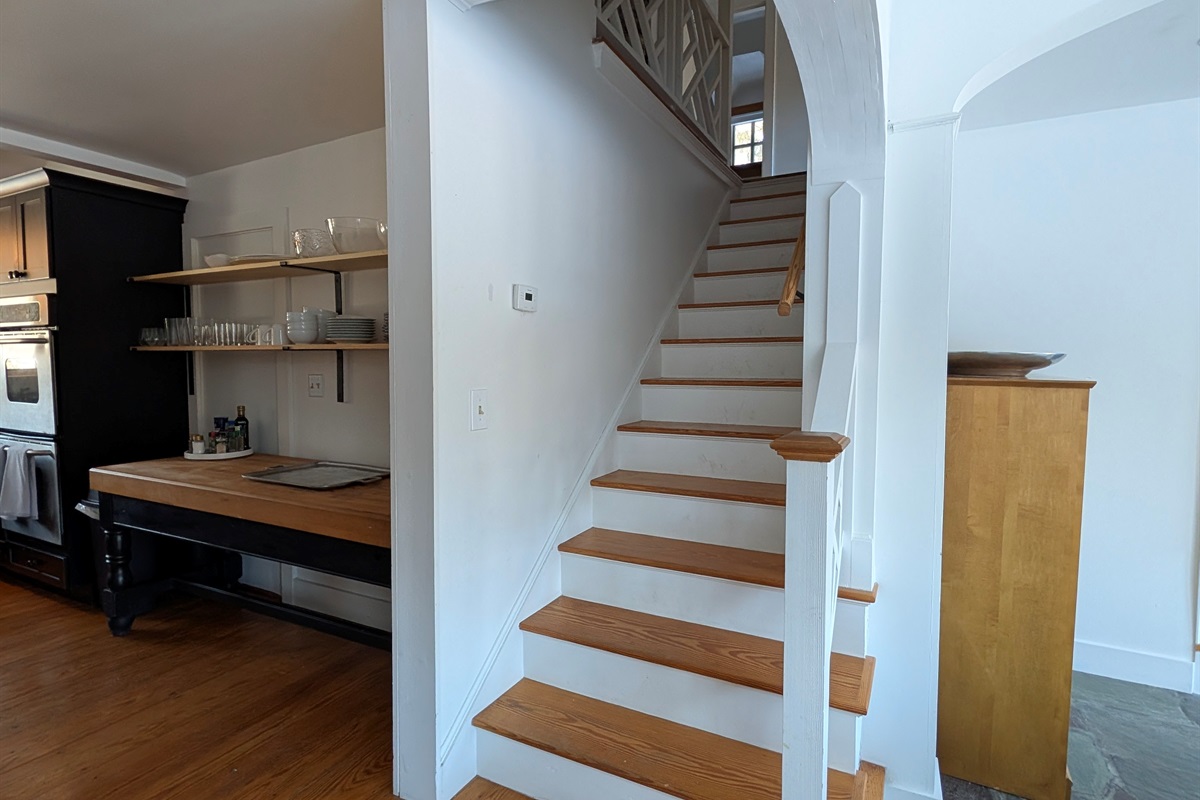 Graceful stairway with wood treads and traditional details, seamlessly integrated into the home’s open layout.