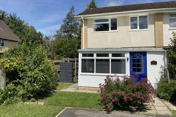 The front of the house fronts onto a green