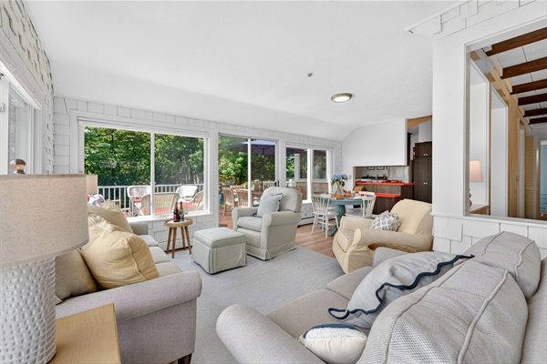 Living room filled with natural light from wide windows, creating a bright and airy atmosphere with a cozy and inviting seating area.