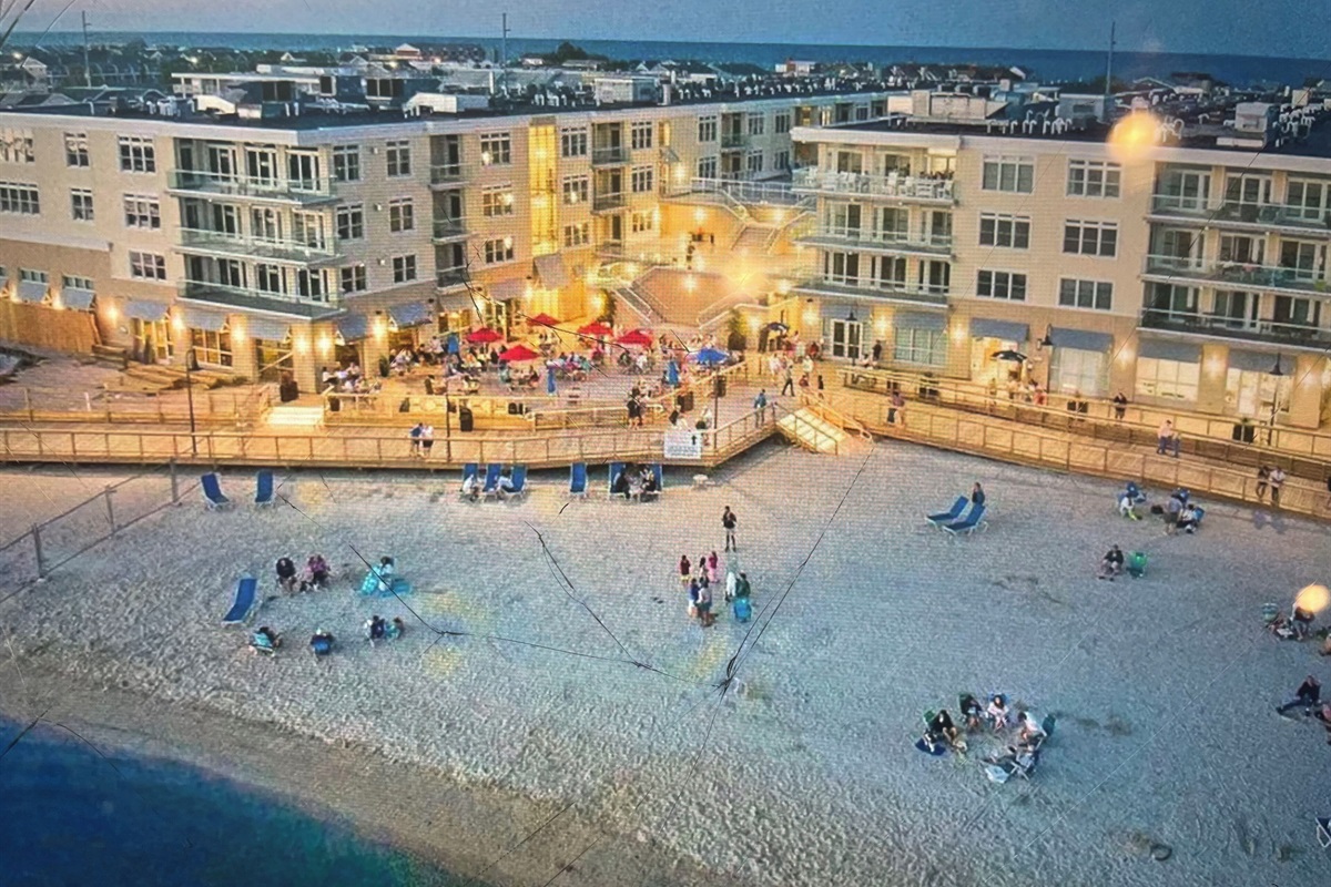 Aerial view of back of building with bay beach and boardwalk areas