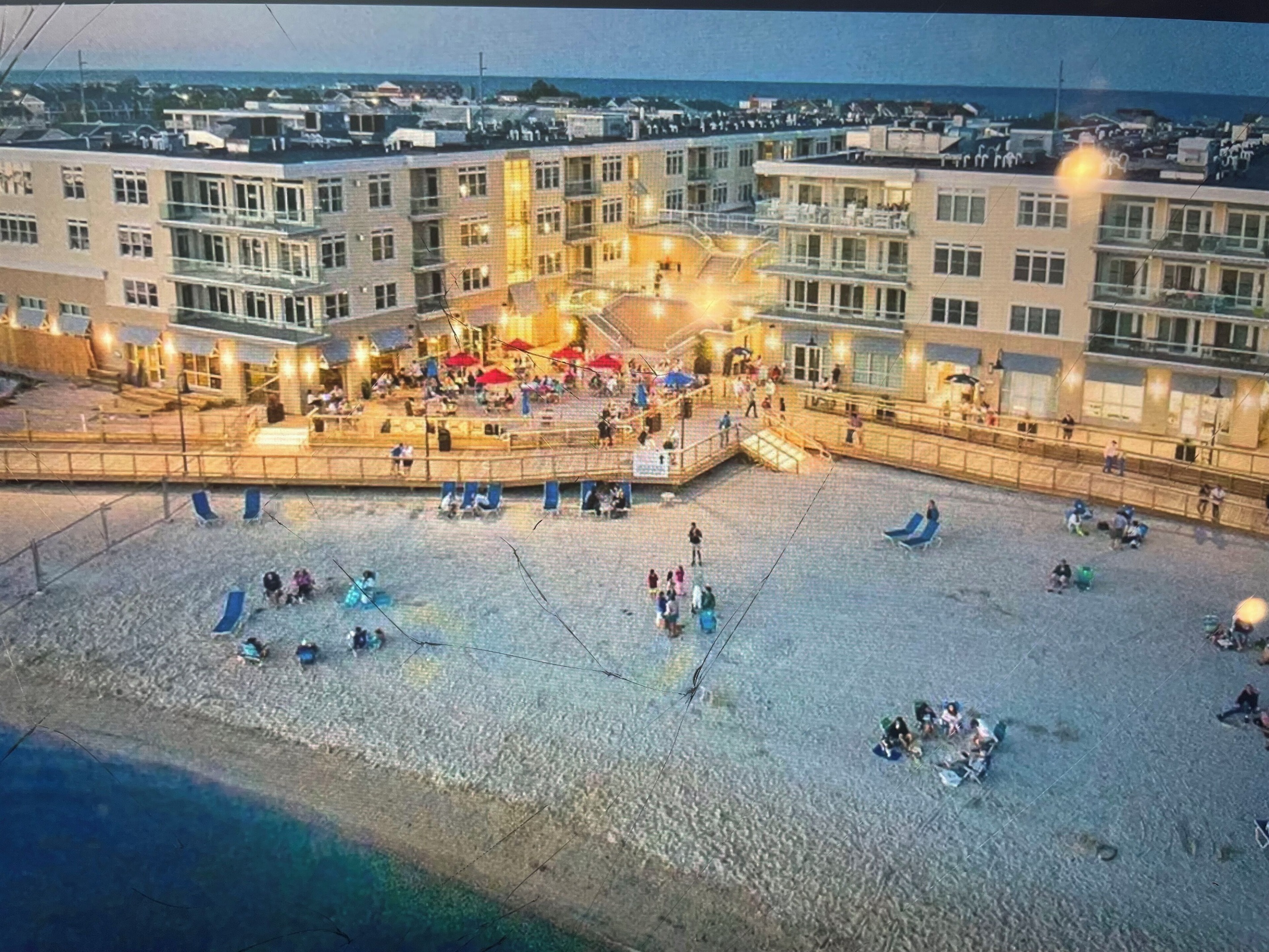 Aerial view of back of building with bay beach and boardwalk areas