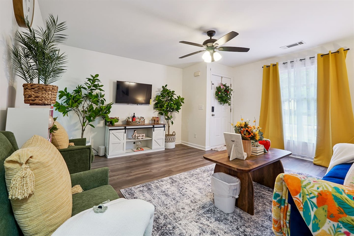 The living room features cozy furniture, including a comfortable blue couch, and an Amazon Fire-powered Smart TV for your entertainment. You’ll also find the Xfinity modem conveniently located here, convenient for ethernet connection.