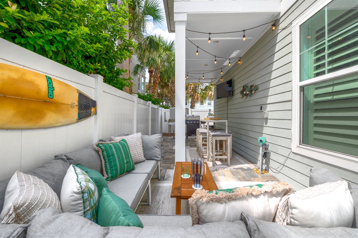 Outdoor courtyard lounge seating area with TV