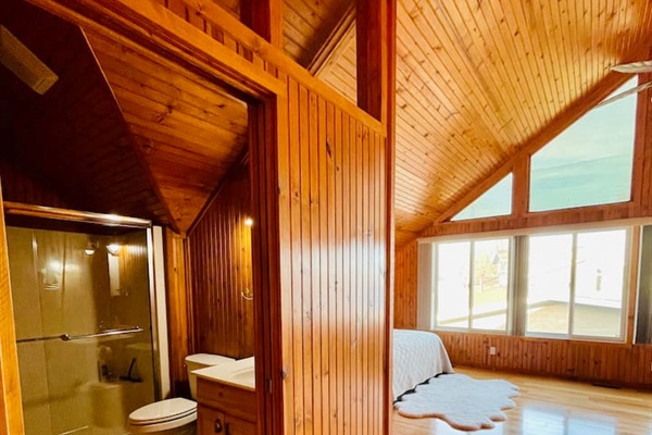Bright big master bedroom with a panoramic lake view.