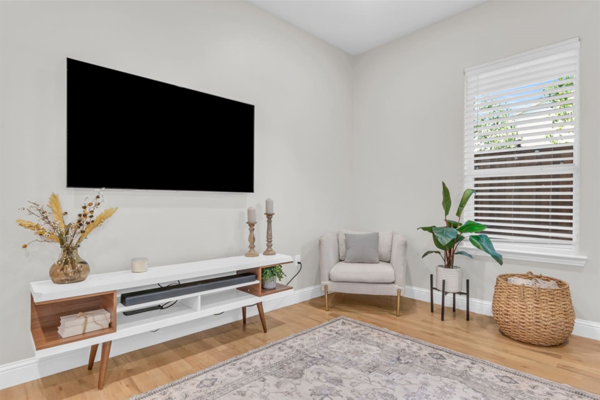 Living room with mounted flat-screen TV and cozy seating.
