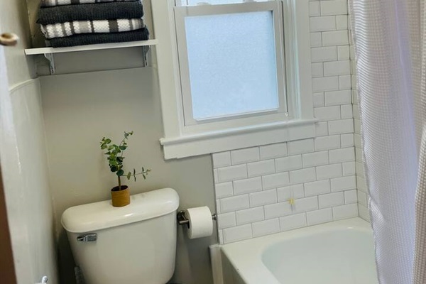 Full size tub with shower in the bathroom.