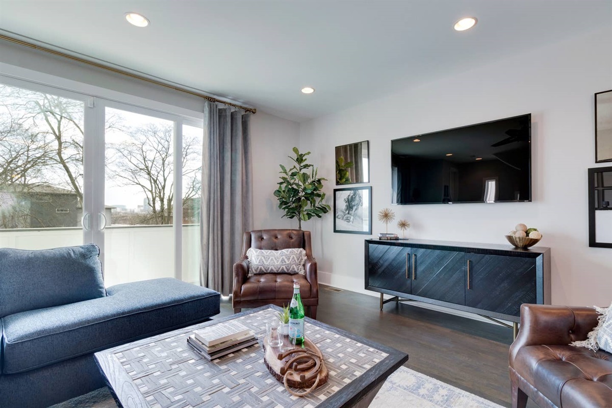 - Modern media wall with flat screen TV, leather chairs, and layered artwork - Natural light pours in from sliding doors leading to the private balcony - Relax and stream your favorites in this thoughtfully designed entertainment space  