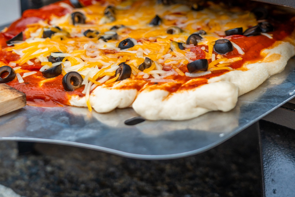 Watch the cheese bubble and pull it at exactly the right second — the pizza oven turns dinner into the evening's entertainment.
