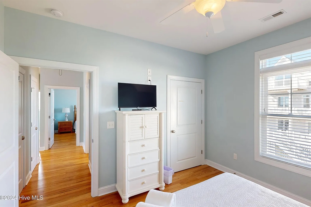 Brightly lit bedroom with ample storage and a private TV