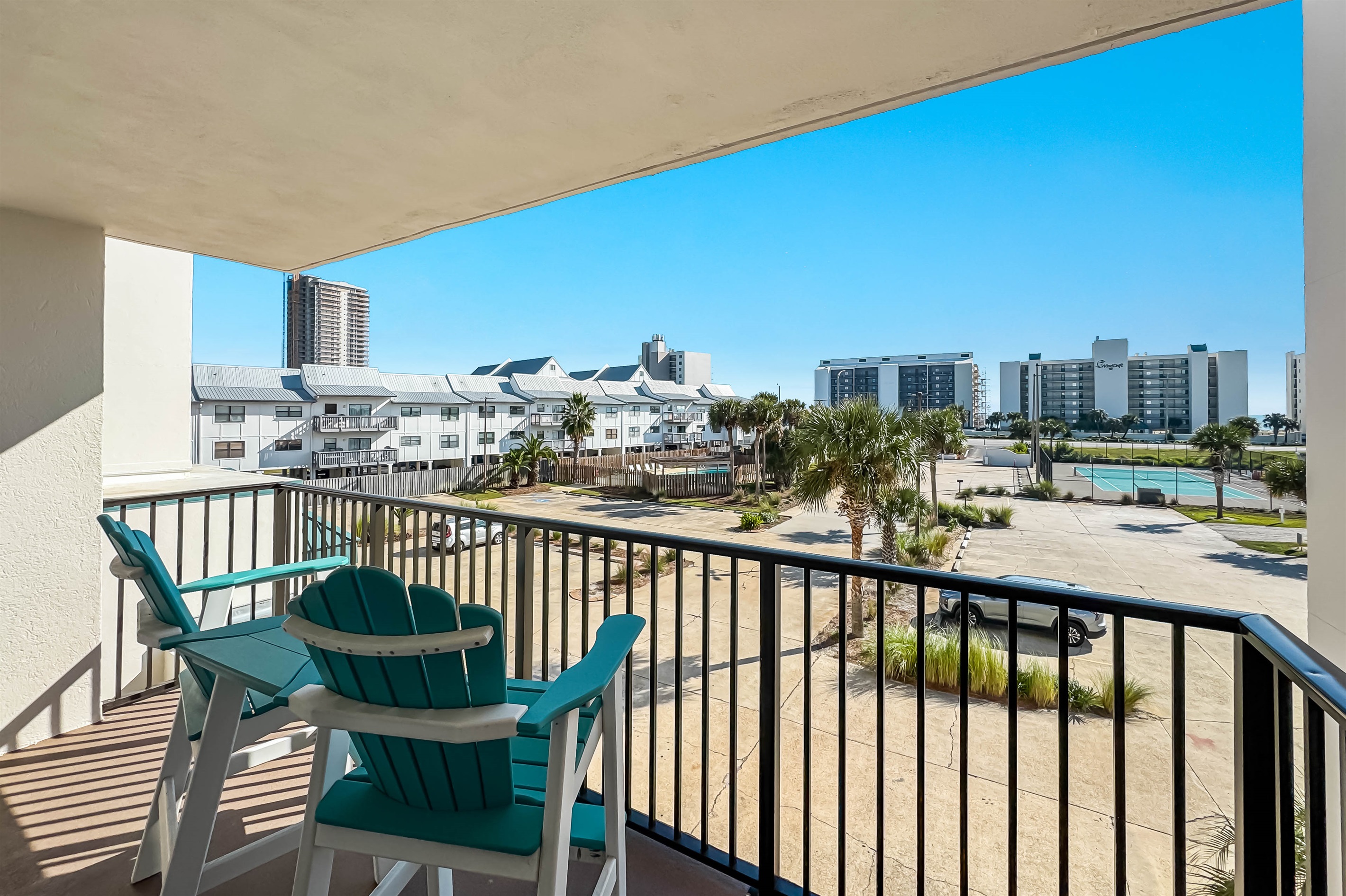 Step onto your private balcony and soak in the vibrant atmosphere. This view offers a perfect blend of tropical landscaping and convenient access to resort amenities. Enjoy your morning coffee or evening cocktail while overlooking the complex.