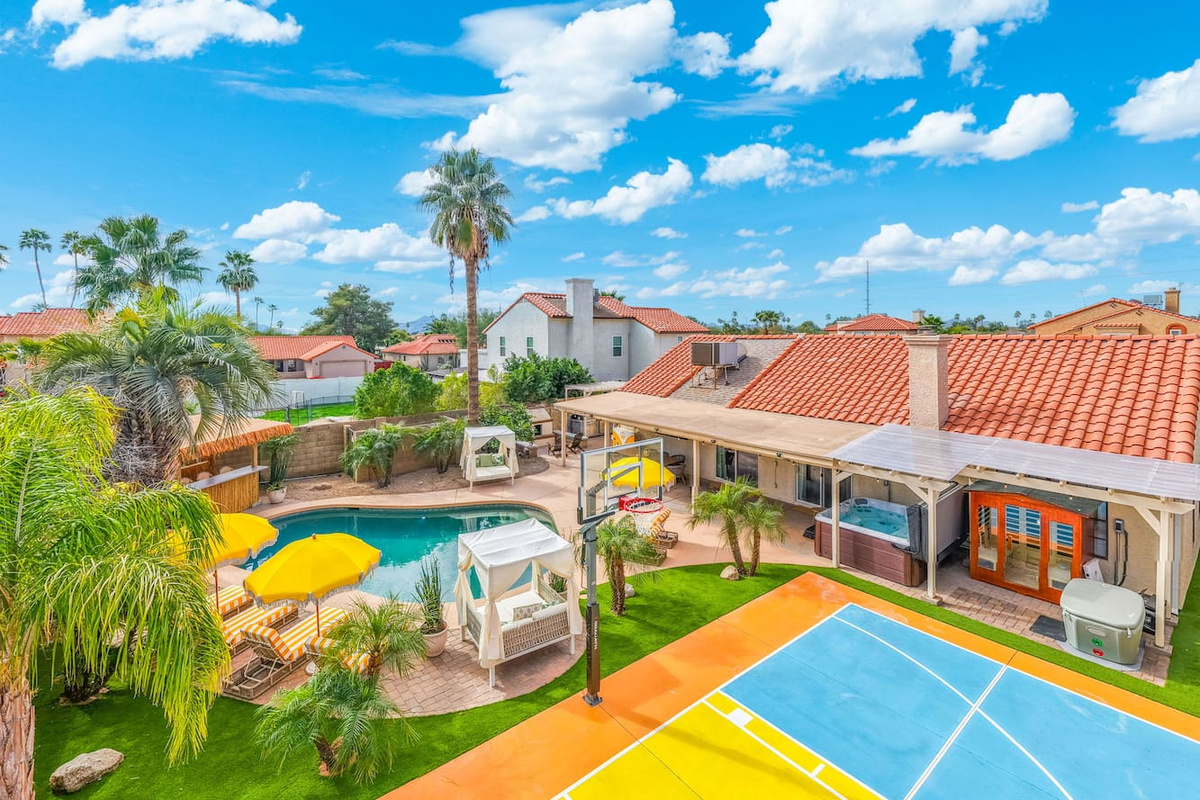 Expansive backyard resort with pool, spa, basketball court, and lush landscaping—an entertainer's dream with desert views.