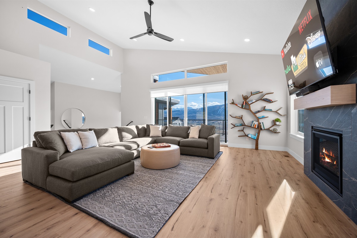 Expansive living room with soaring ceilings, modern décor, and majestic mountain views.