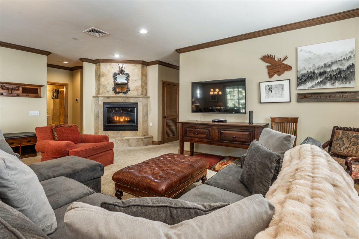 Comfortable living room with deep seating, warm fireplace, and a generous sectional—perfect after a day on the mountain.