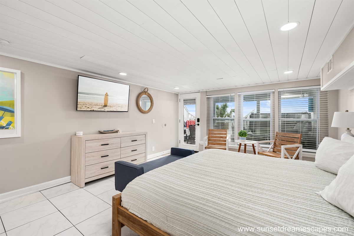 The downstairs beachside west bedroom is equipped with a king bed, seating area, and 55" Roku-enabled TV. Guests may relax after a sun-filled day in the private ensuite full bathroom.