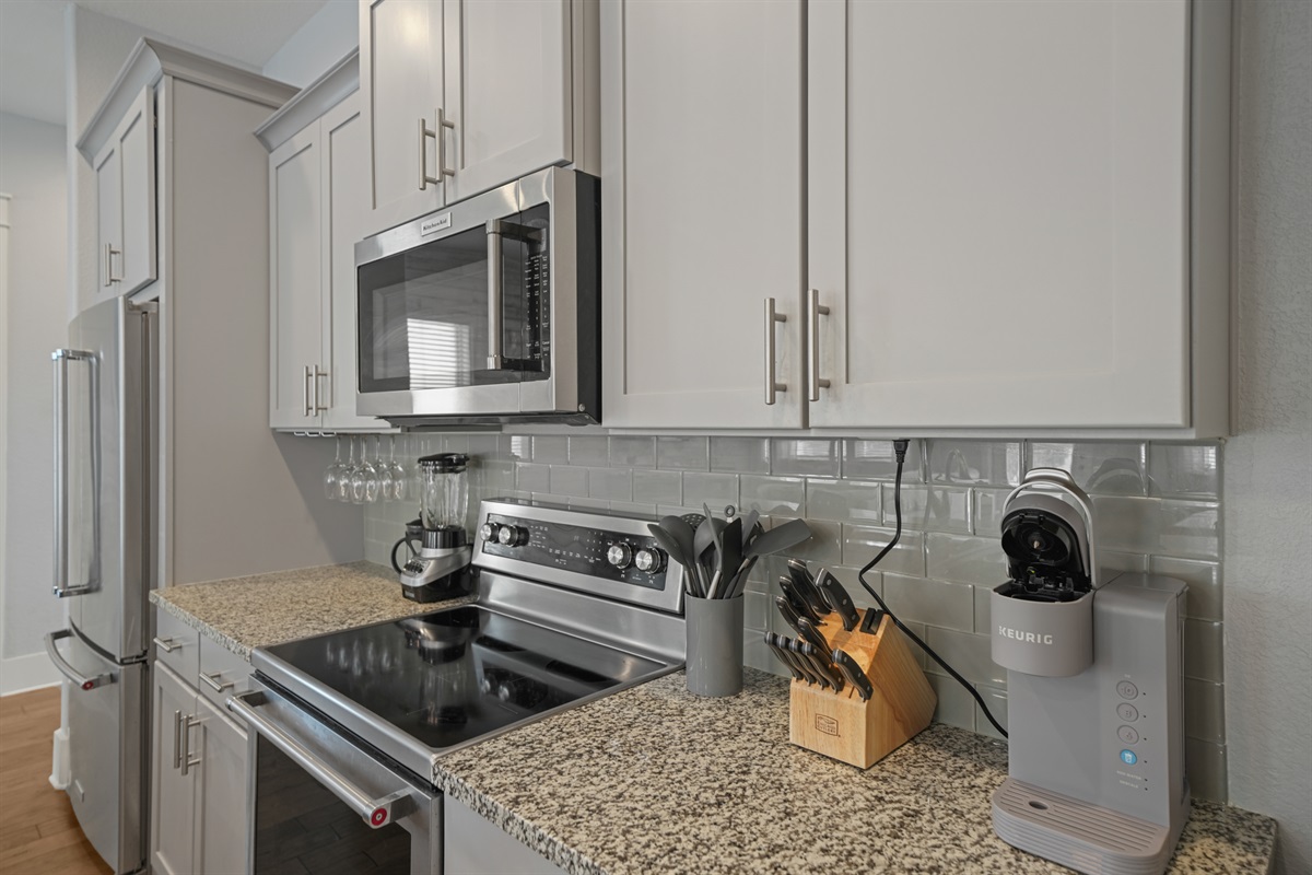Modern kitchen with stainless steel appliances, granite countertops, and ample cabinetry.