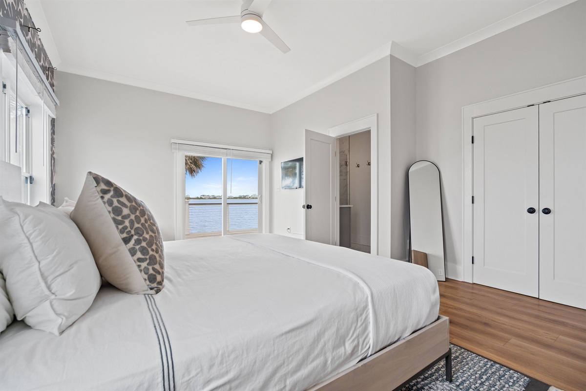 Wake up to beautiful water views from this serene king bedroom featuring direct patio access and private ensuite bath