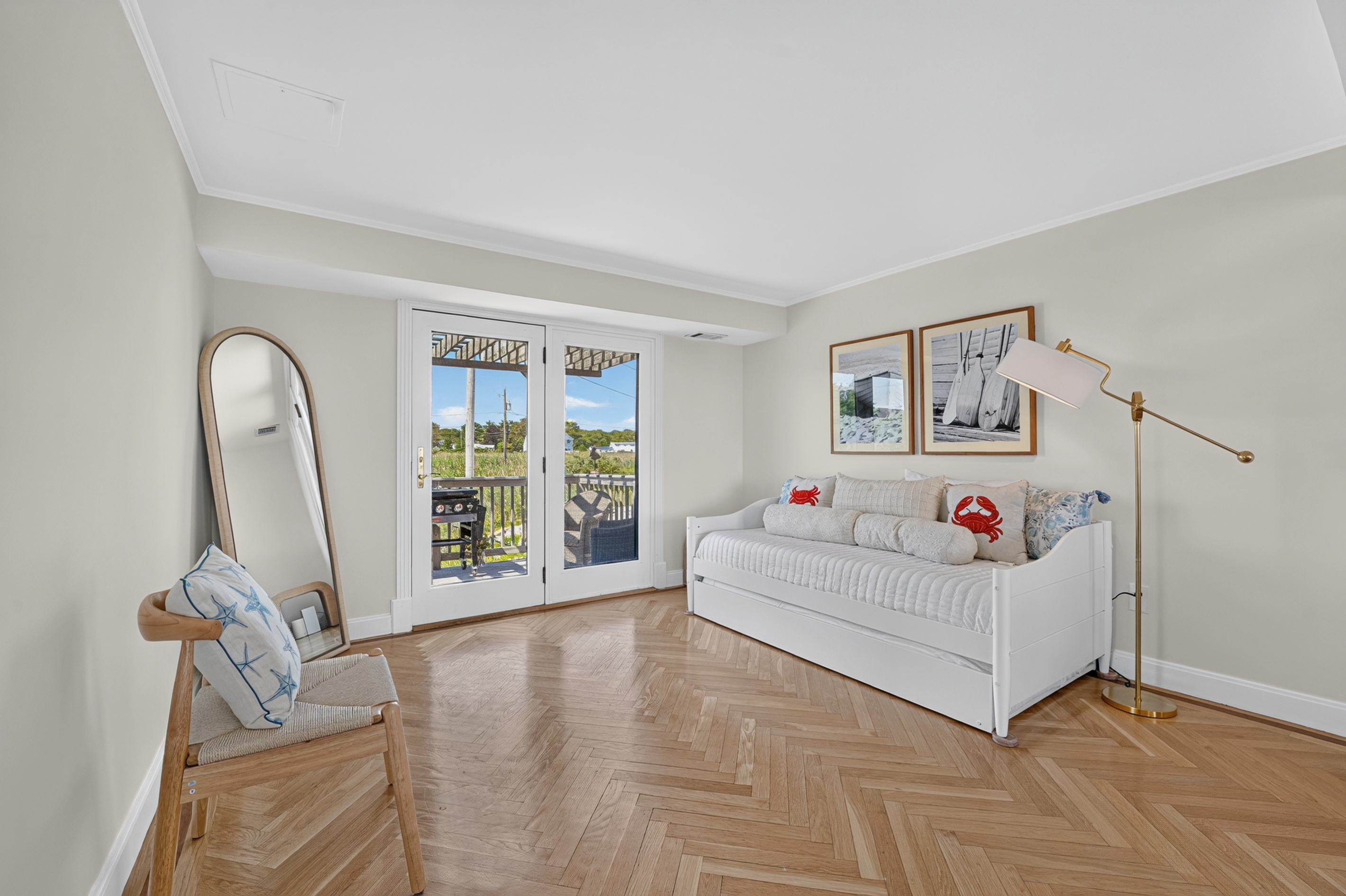 Airy bedroom with coastal décor, natural light, and comfortable sleeping accommodations.