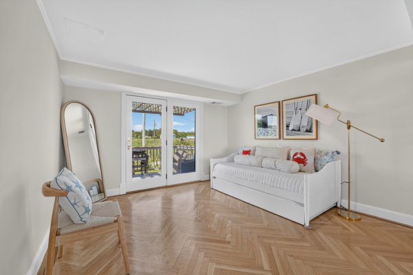Airy bedroom with coastal décor, natural light, and comfortable sleeping accommodations.