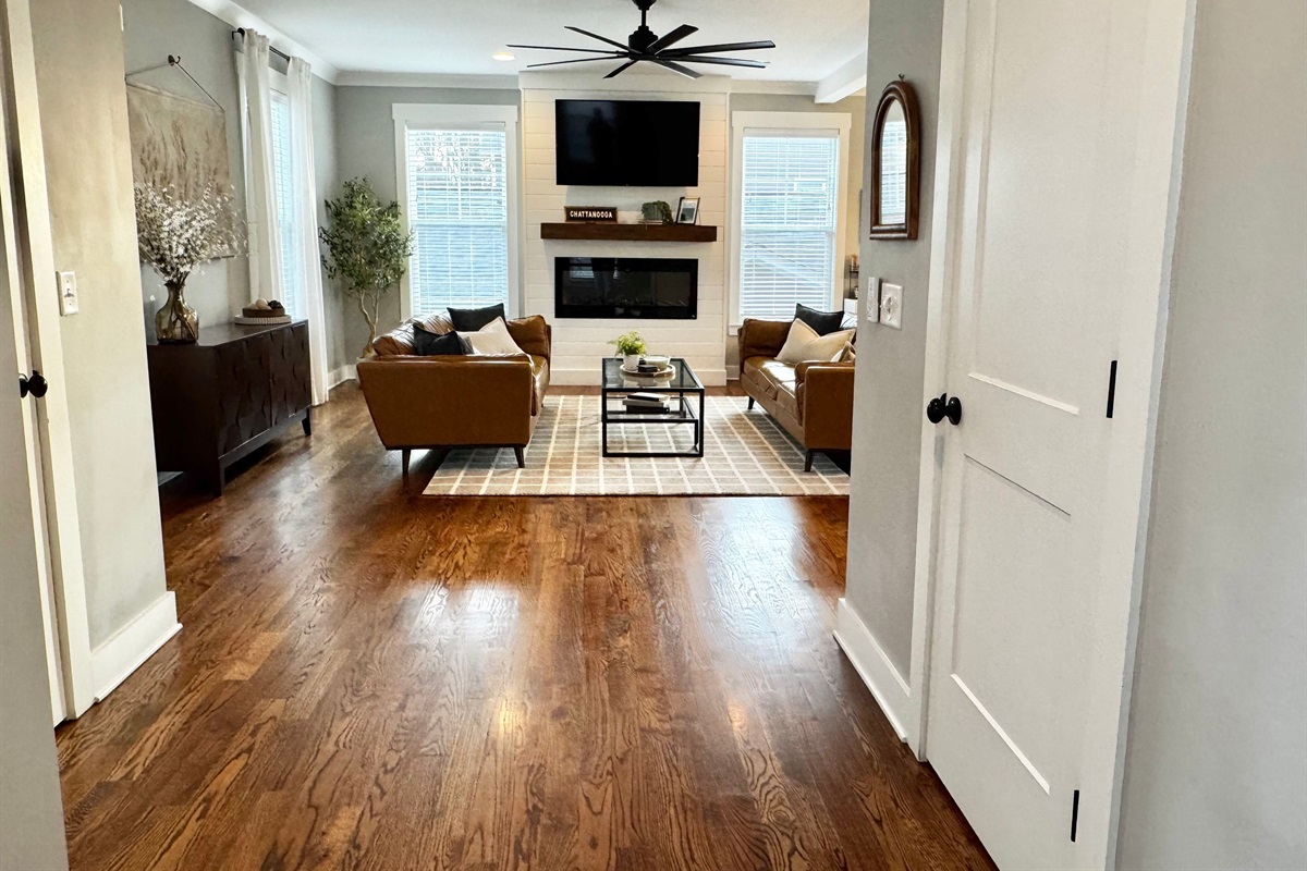 Just inside the front door, you will find the main living space with the living room, fireplace, TV, kitchen, dining room, half bath, coat closet, and outdoor patio with a grill, dining table, and amazing view!