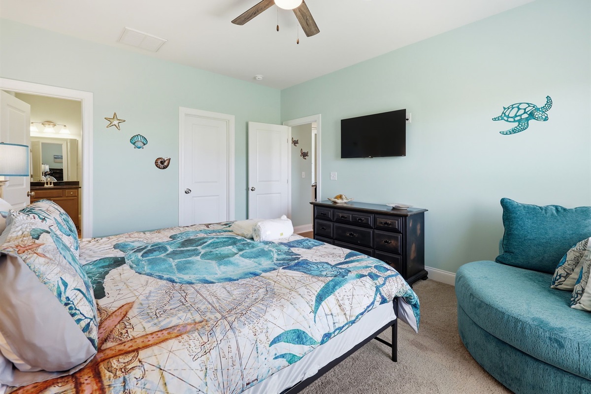 King suite with smart TV, seating area, and calming coastal design