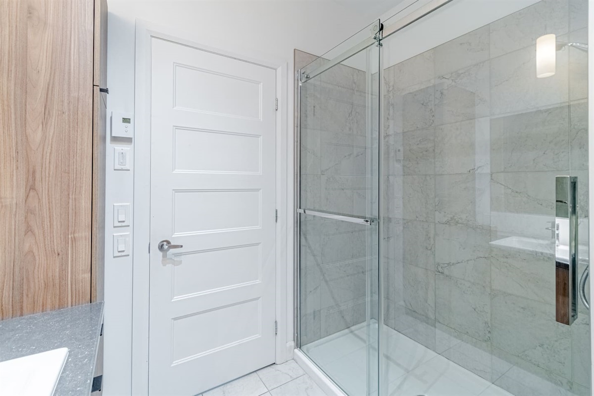 Salle de bain moderne et complète avec douche.