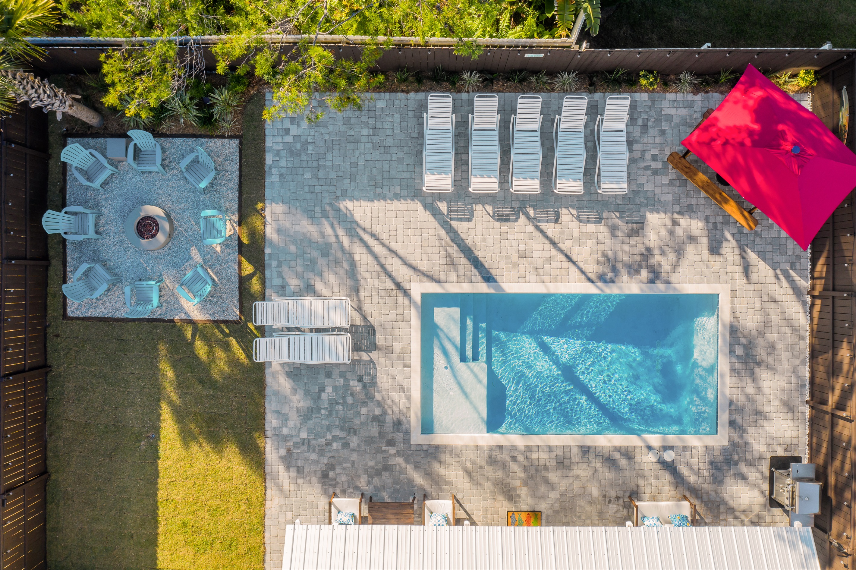 Relax in your private outdoor oasis featuring a sparkling pool, ample sun loungers, and a cozy firepit area. Perfect for sunny Miramar Beach afternoons.
