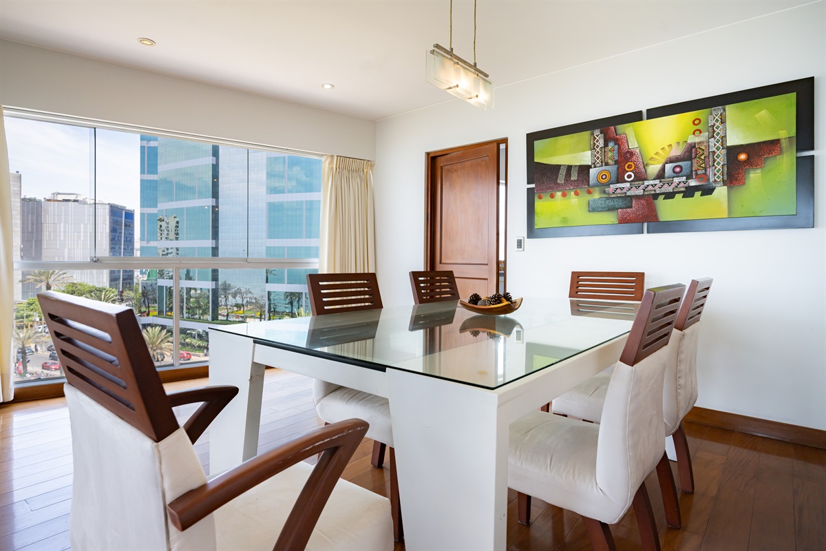 Dine Above the Ocean: A spacious dining area integrated with floor-to-ceiling glass, showcasing the vibrant Malecón and the coastline