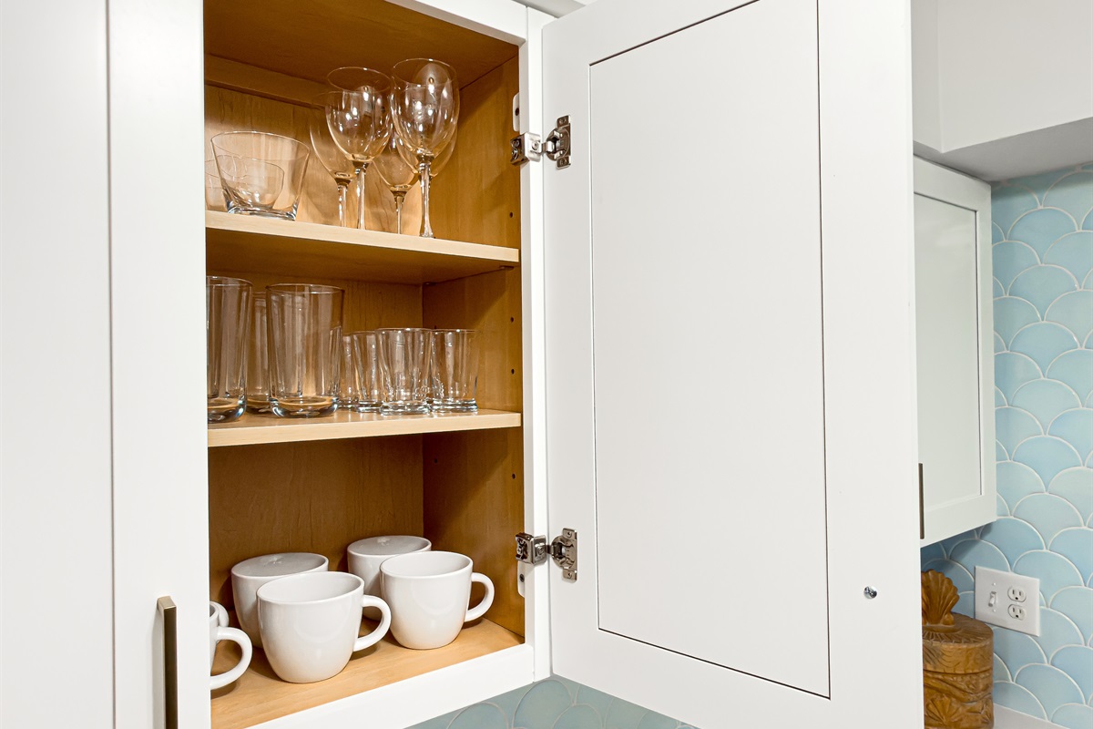 Wine glasses are clean and ready in the upper cabinet for a quiet drink at the island after the sun goes down.