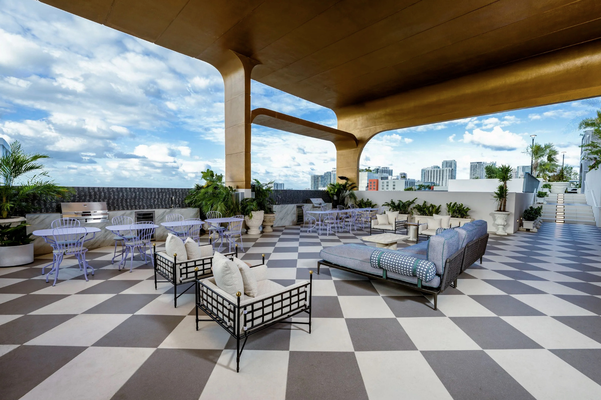 Lounge on the rooftop terrace - checkerboard decking, shaded seating and open-air Miami evenings.