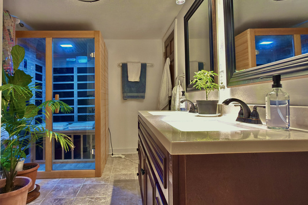 Spa-inspired bath with double vanity, live plants, and customizable infrared sauna. A serene space to relax and rejuvenate during your stay.