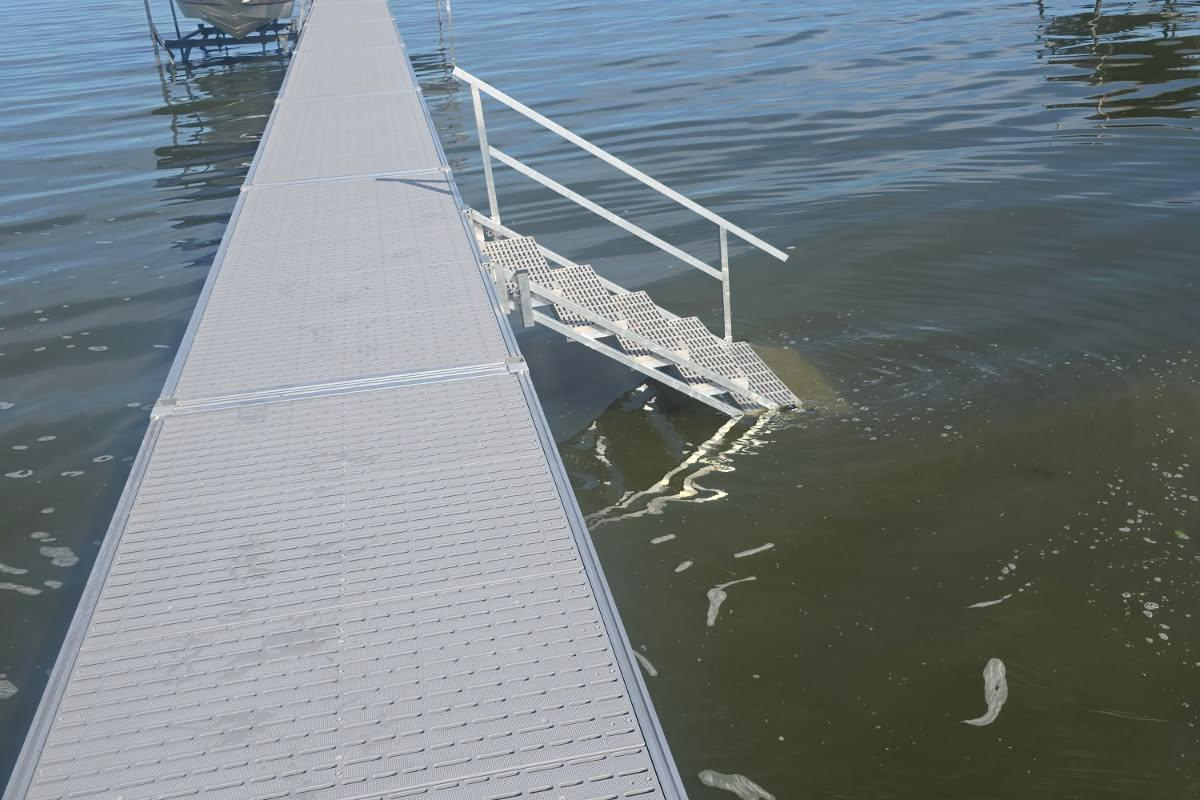 Private dock over 100 feet with bench on "patio" at end of dock and stairs into water