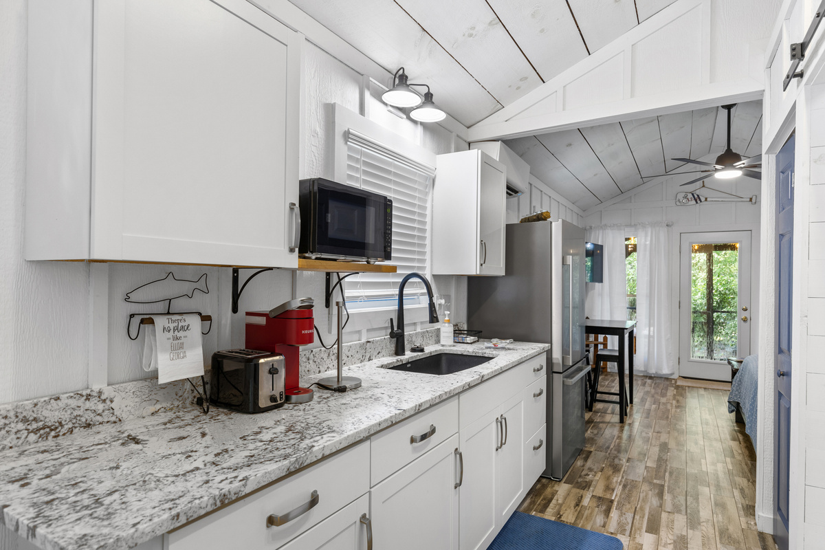 The private guest cottage includes a queen bed, kitchenette, full bath, and screened porch.
