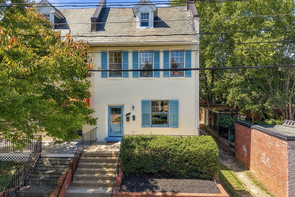 Exterior: Charming brick facade with vibrant blue shutters and inviting garden steps await!