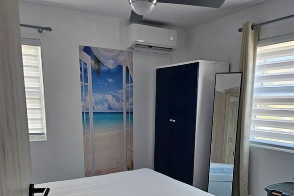 Queen size bed, new mattress, full length mirror, darkening curtains, remote controlled A/C, ceiling fan, and wardrobe