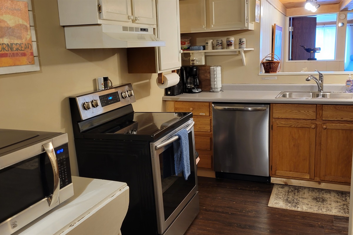 small full kitchen - stocked with the essentials for cooking and serving (utensils, plates, cups, pots, pans, etc.)