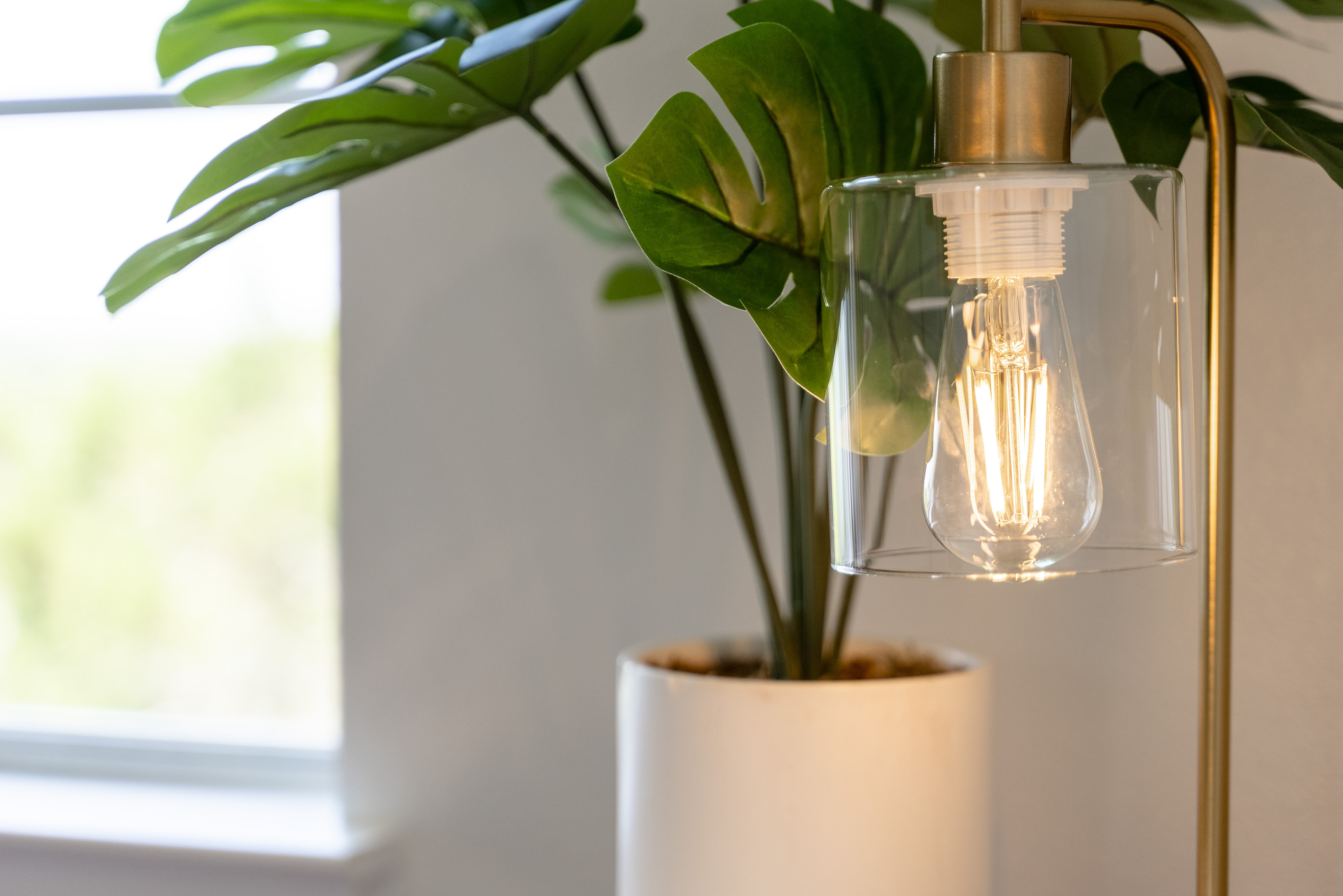 Warm pendant lighting pairs with lush greenery for a cozy, boho touch.